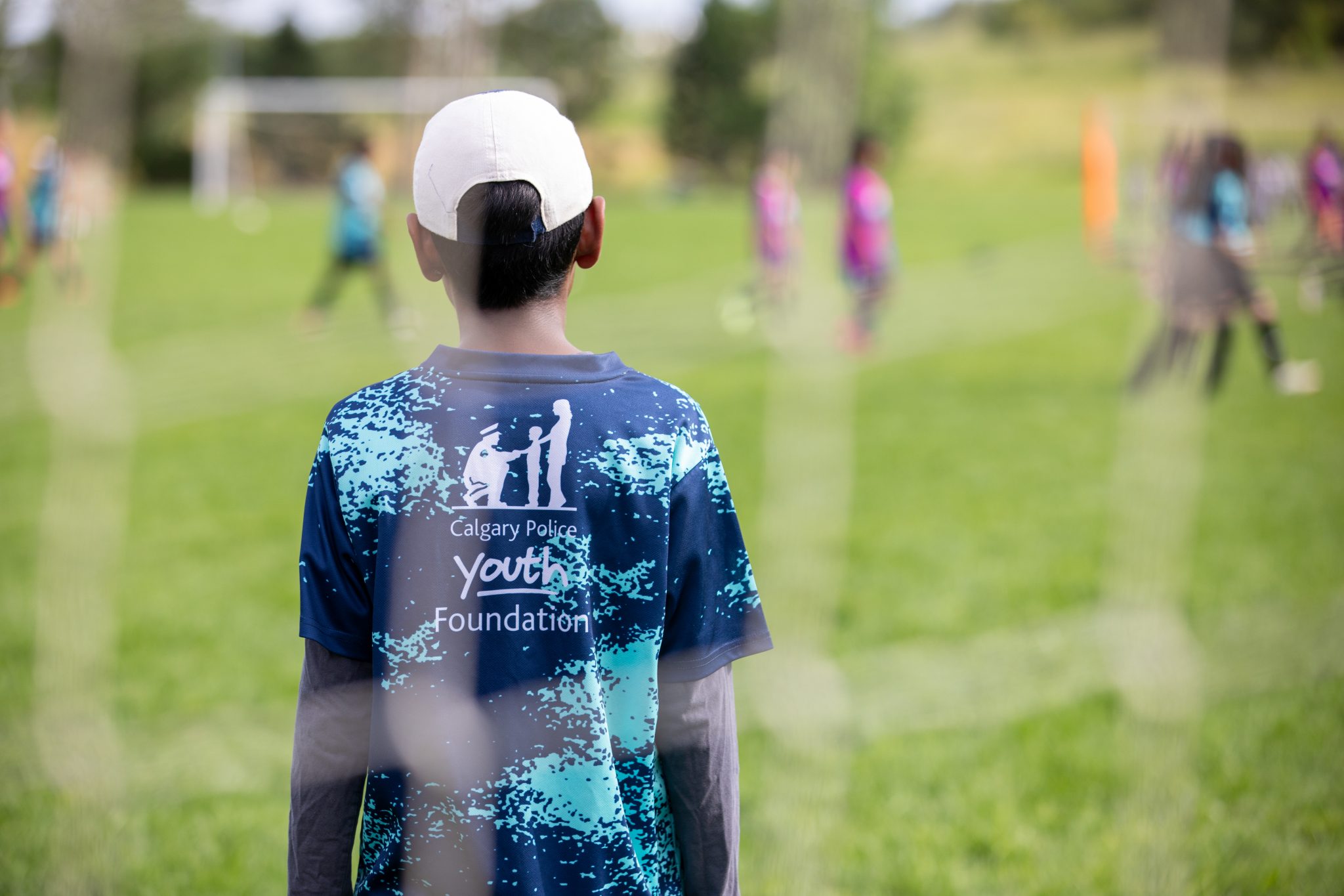 Child in blue shirt watching soccer